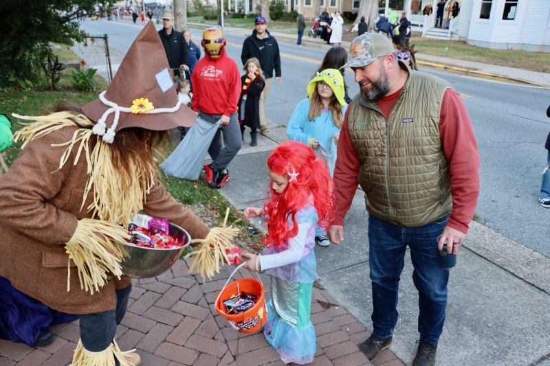 A scarecrow, played by Eva Stenkowski, left, hands candy to a mermaid, played by Cameron Backus.